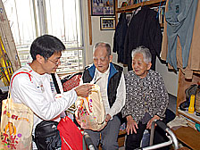 愛心百福: 來自社會各階層的義工5月26日探訪深水埗居民，向居住在板間房家庭派發愛心百福袋。
