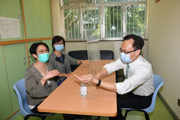 保障措施:聶德權（右）到訪社會福利署銅鑼灣綜合家庭服務中心，了解中心採取減少社交接觸和預防感染措施，包括提供輔導服務的接見室裝設間隔。