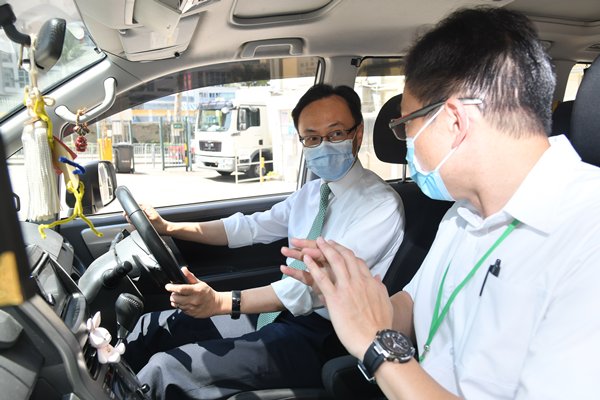 保持警剔:聶德權（左）到訪運輸署培正道駕駛考試中心，聽取考牌主任介紹恢復駕駛考試路試時所需採取的防感染措施。