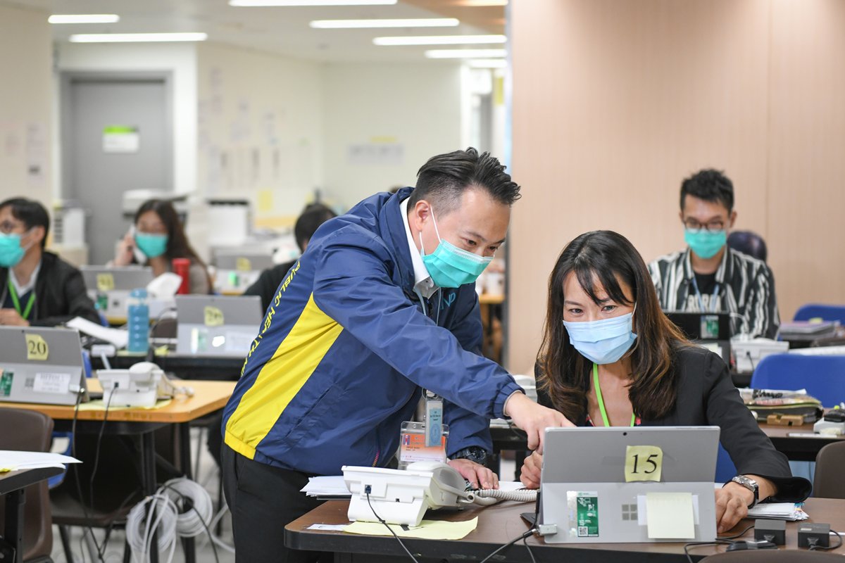 解答疑難:衞生署護士長謝漢宇（左）和衞生署高級牙科醫生何慧美於疫情期間被調派至臨時緊急熱線中心，運用專業知識解答市民查詢。