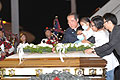 CS places flowers on a coffin